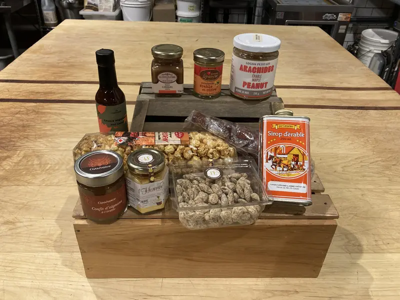 Sauce piquante, confits, noix et arachides du Québec sur une caisse en bois